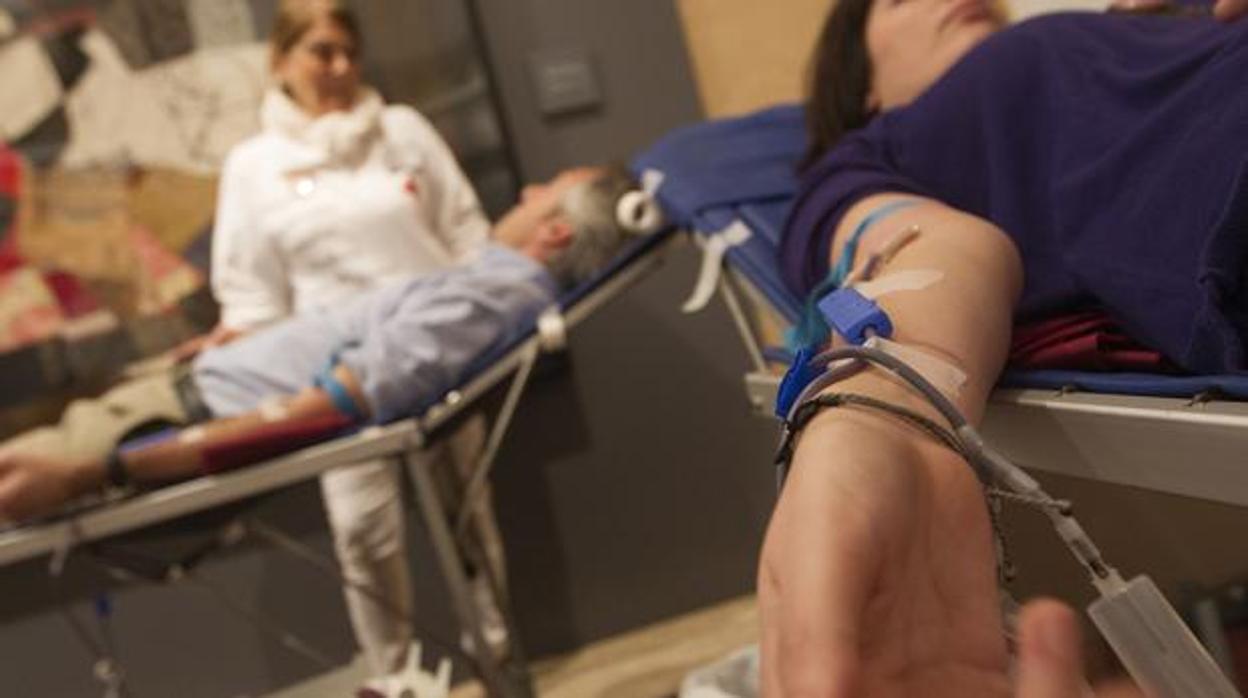 Dos ciudadanos donando sangre en un centro sanitario