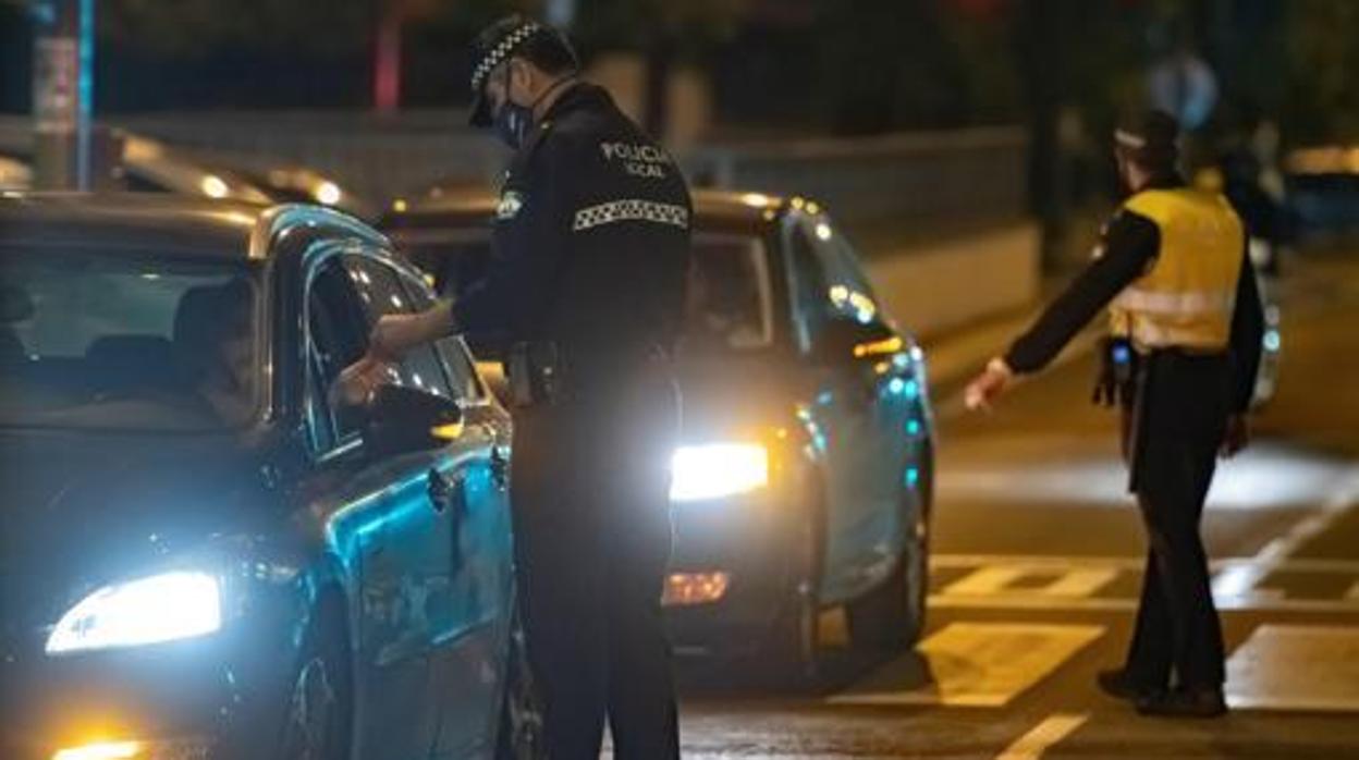 Miembros de la Policía Local de Sevilla piden documentación a conductores para ver si cumplen con el toque de queda de Andalucía