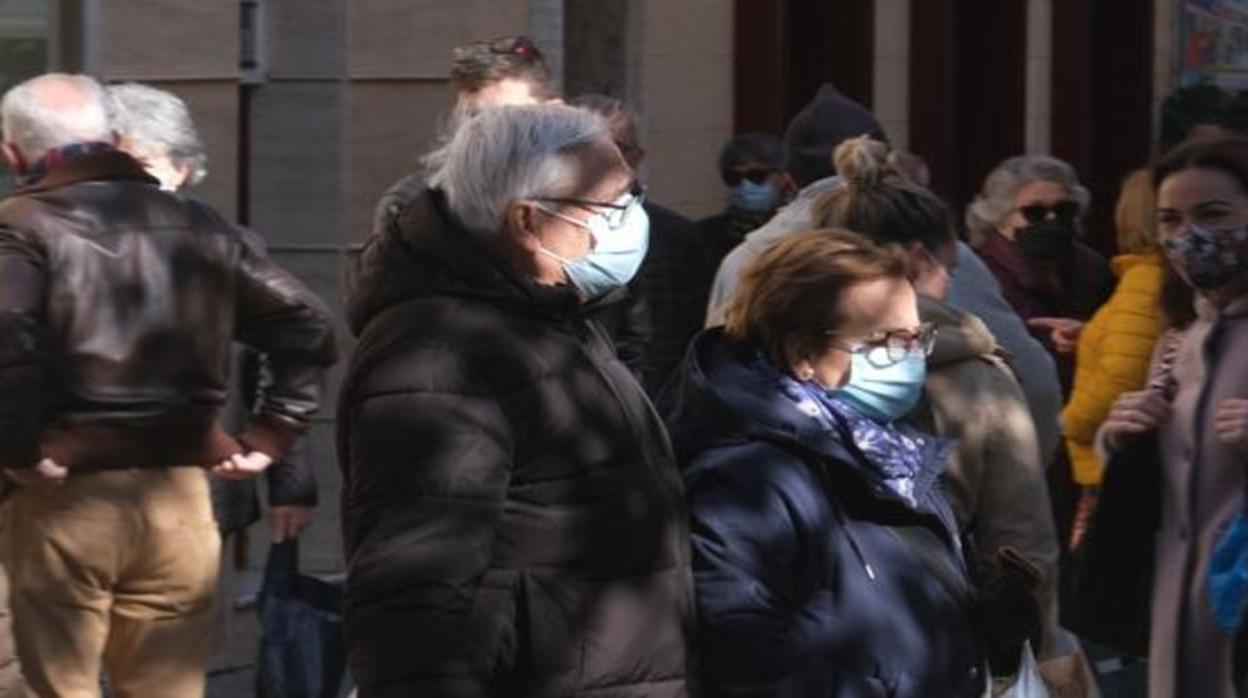 Viandantes con las mascarillas puestas y abrigados por las bajas temperaturas