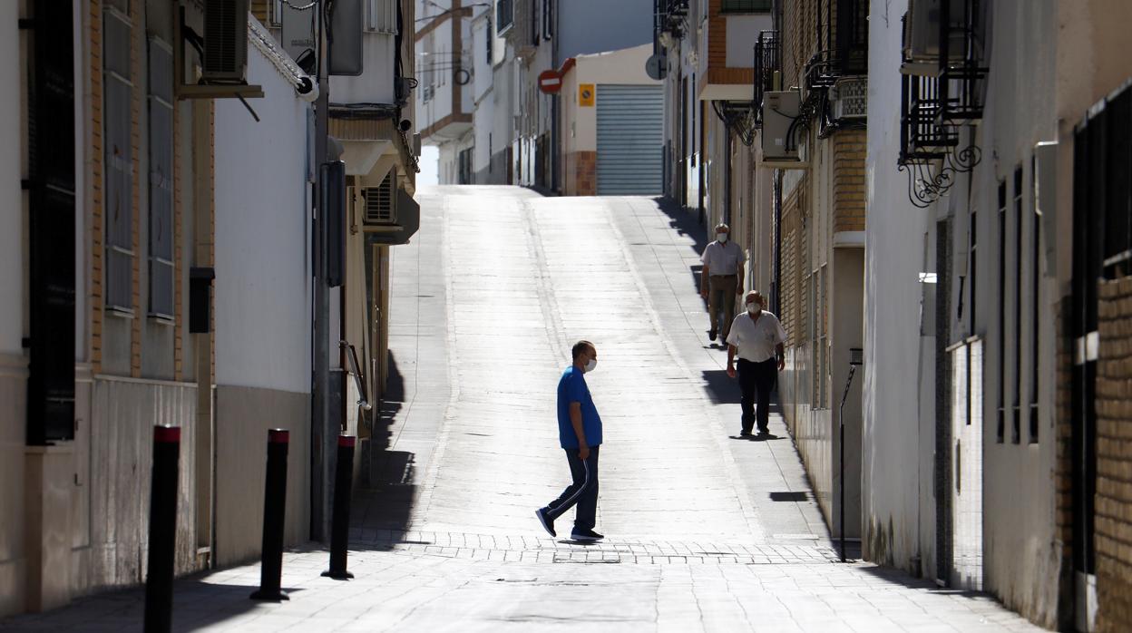 Varios vecinos caminan por una calle semidesierta de Montalbán el pasado verano