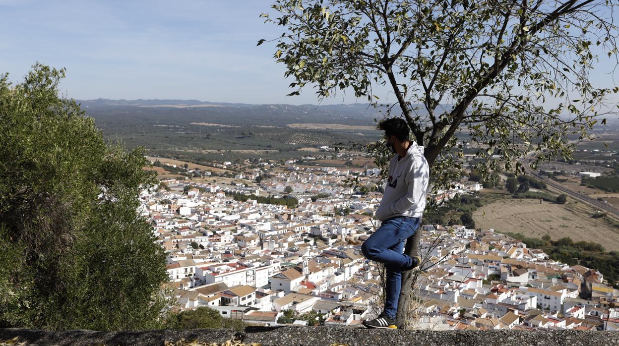 Un joven con mascarilla contempla desde una loma Almodóvar del Río, uno de los nuevos municipios confinados