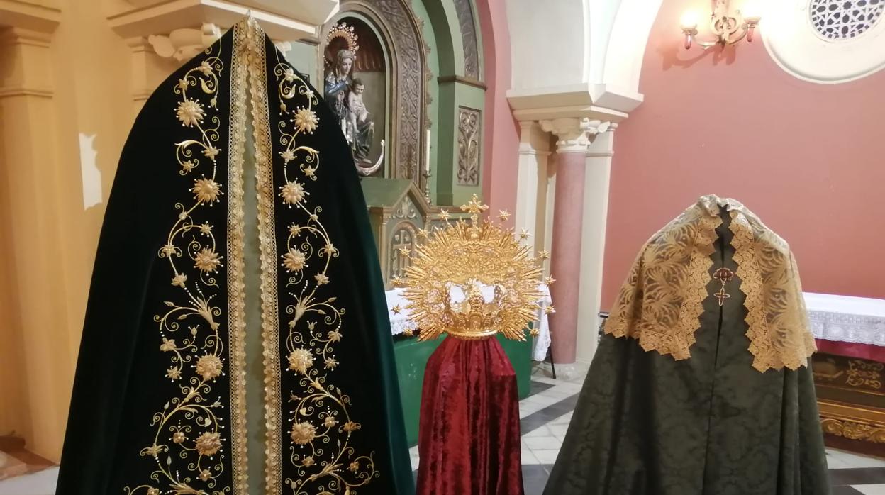 El nuevo manto para la Virgen de la Salud y Consuelo, junto a la corona, el manto adamascado y la toca