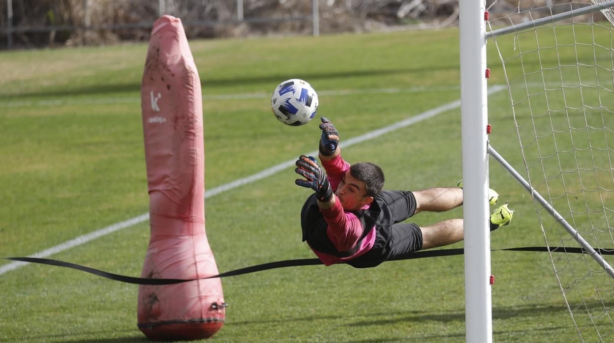 El portero del Córdoba CF Edu Frías vuela por un balón en un entrenamiento