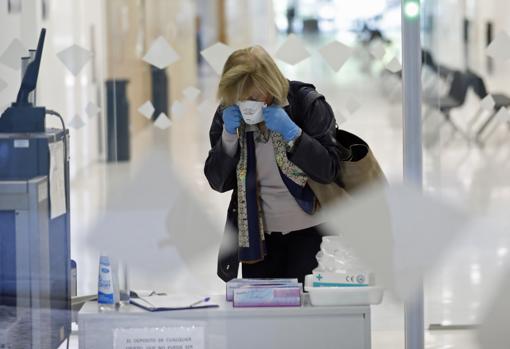 Una mujer se pone una mascarilla al entrar en la sede judicial