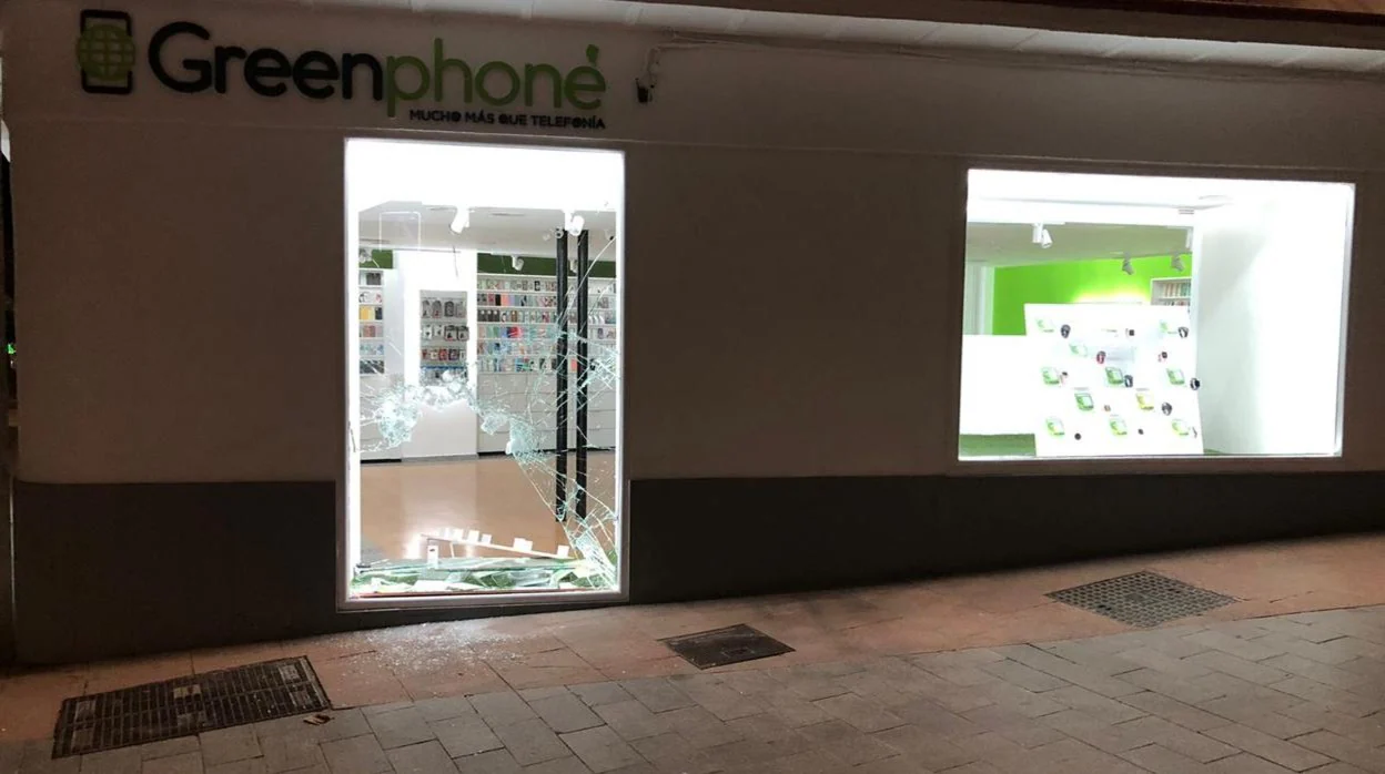 Escaparate roto por los ladrones para acceder a la tienda de telefonía móvil en Lucena