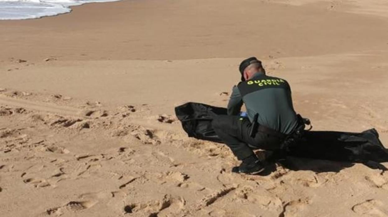 Agente de la Guardia Civil con un cadáver en la playa en una imagen de archivo