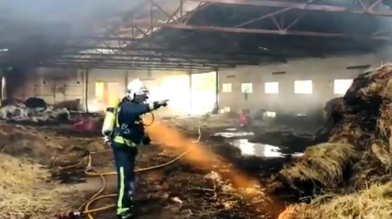 Un bombero durante la extinción del incendio en la nave cercana a la carretera del Aeropuerto