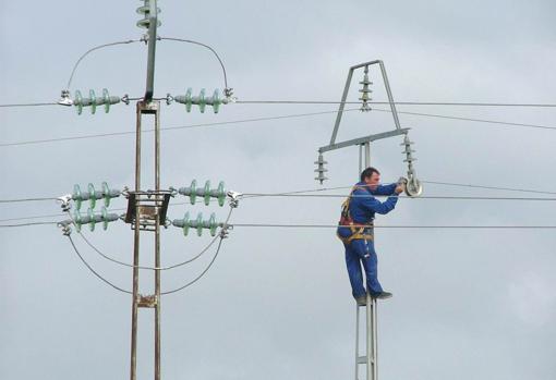 Un operario trabaja en una torre de energía eléctrica