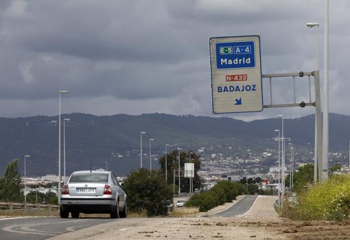 Un coche junto a una señal de la carretera que va a Badajoz