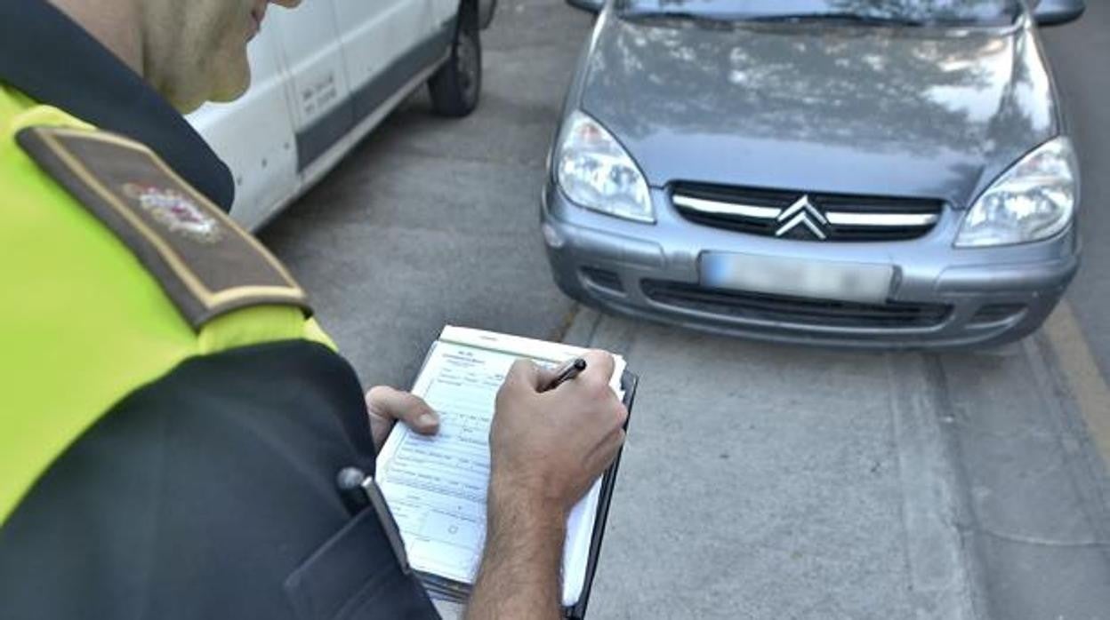 Un agente poniendo una multa a un conductor en una imagen de archivo