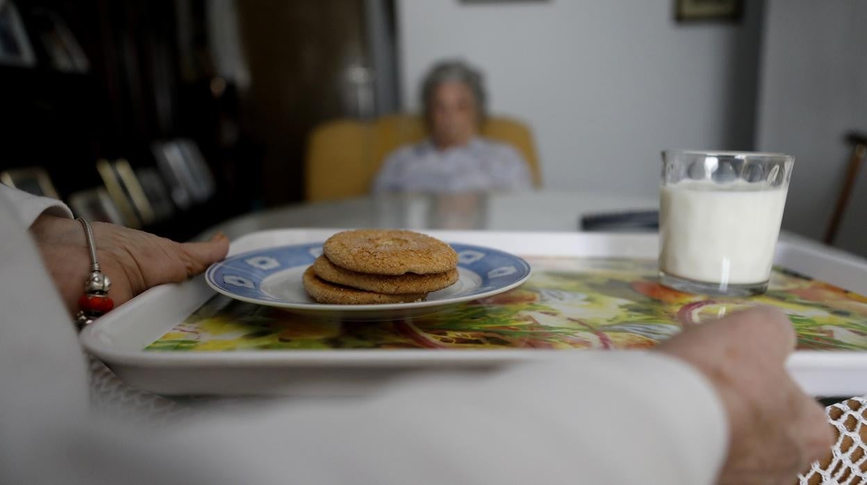 Una familiar lleva la merienda a un dependiente en una vivienda en Córdoba el pasado mes de febrero