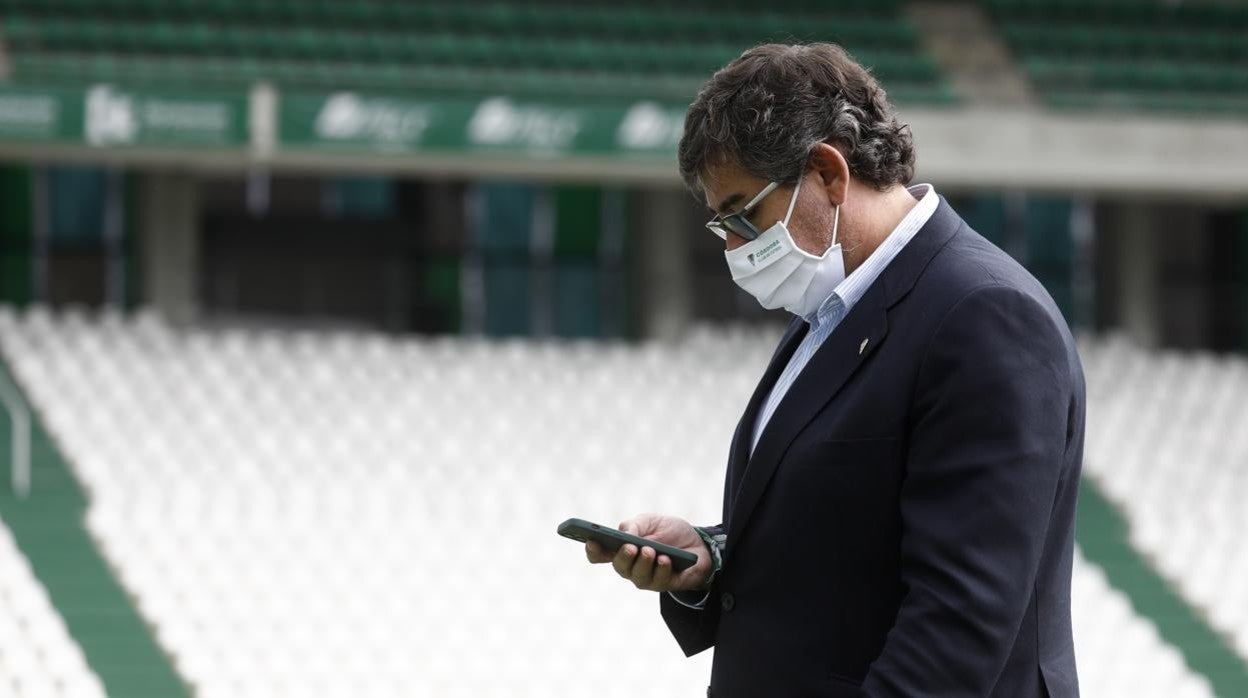 El consejero delegado del Córdoba CF, Javier González, consulta el móvil en el estadio