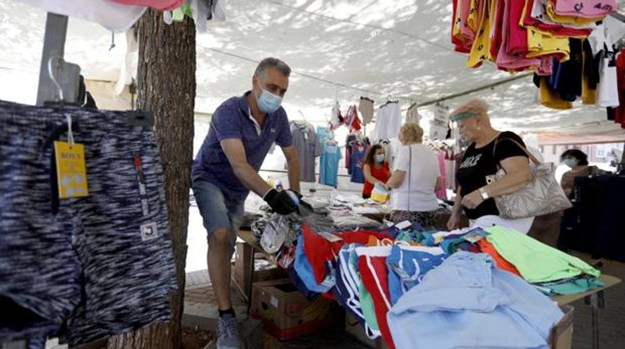 Un vendedor del mercadillo de La Ladera higieniza la ropa de su puesto VALERIO MERINO