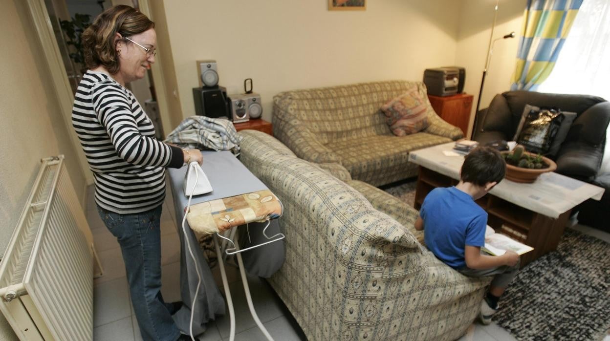 Una mujer planchando en su casa