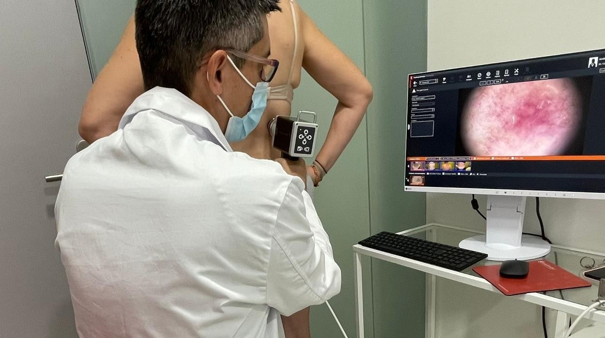 El doctor Tejera emplea un dermatoscopio digital en una paciente