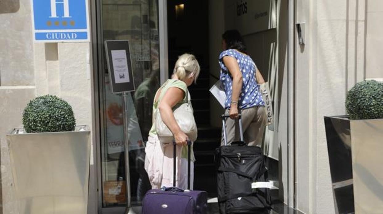 Dos turistas entrando a un hotel de Málaga