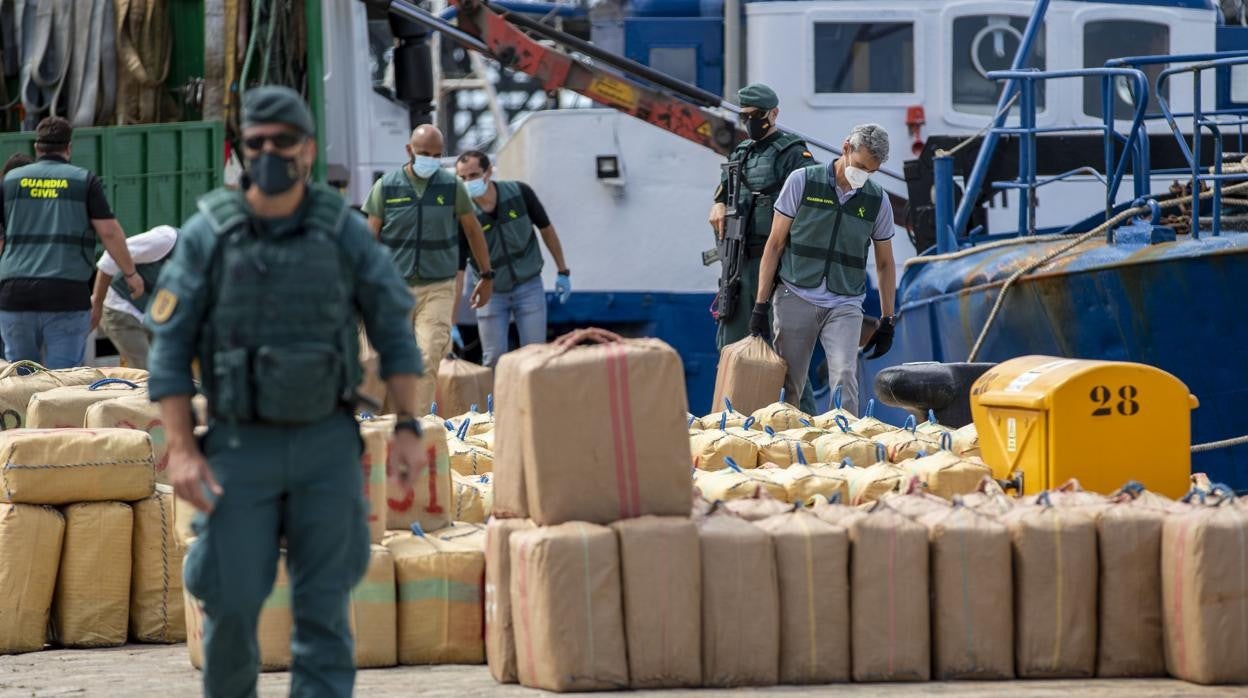 Agentes de la Guardia Civil y de Vigilancia Aduanera junto a la droga intervenida, en el Muelle de Llevante