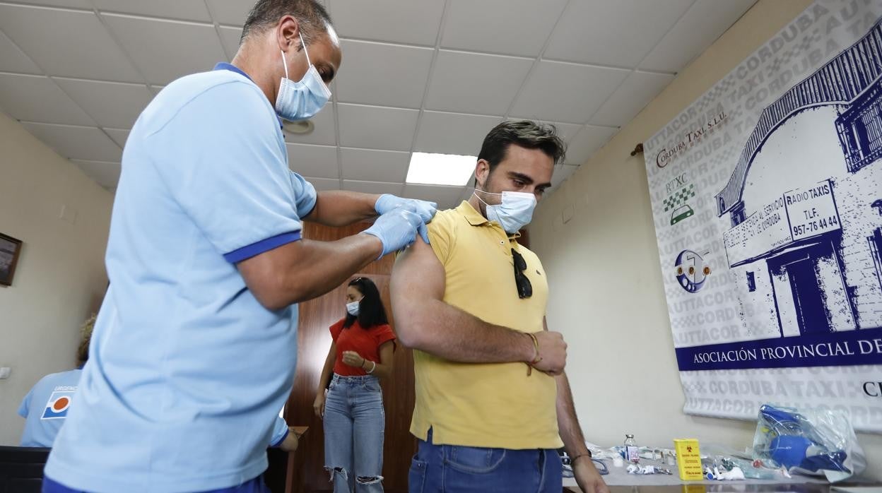 Un sanitario vacuna a un joven en la Asociación Provincial de Autónomos del Taxi de Córdoba