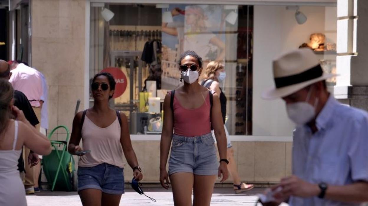 Dos mujeres pasean por Sevilla con la mascarilla