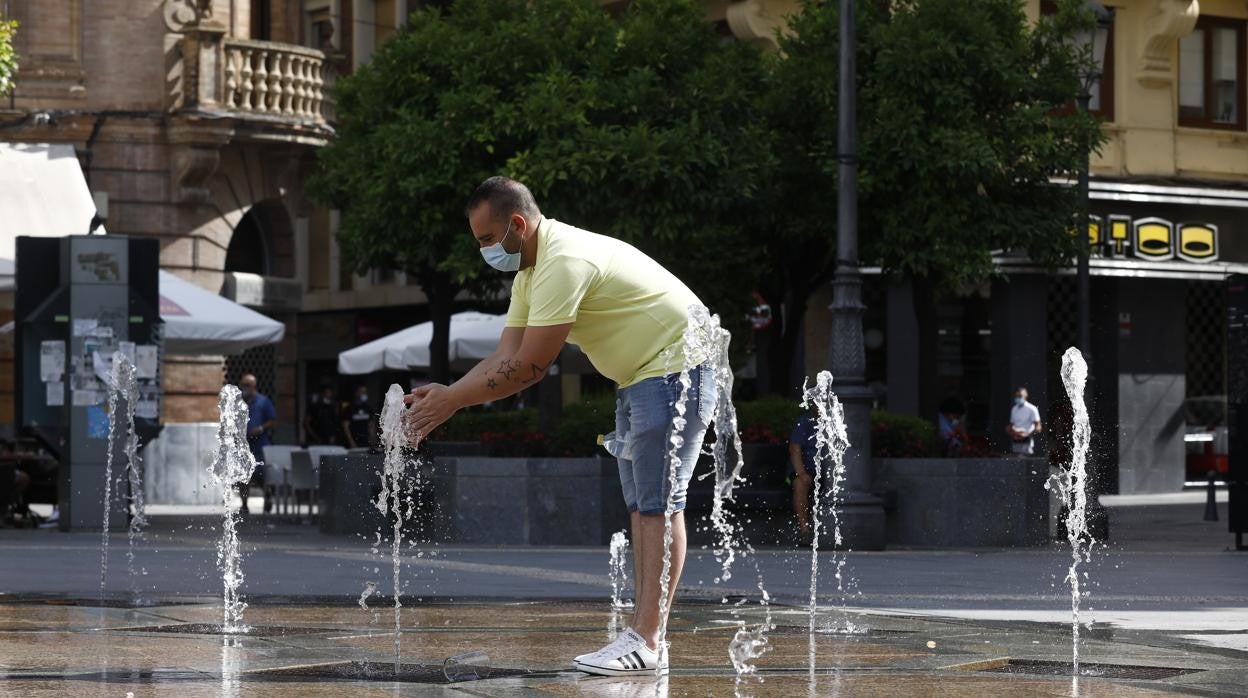 Un hombre se refresca del calor en la plaza de Las Tendillas de Córdoba