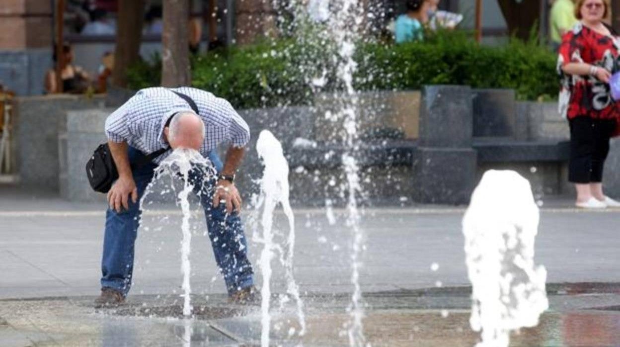 Un hombre se refresca en los chorros de las Tendillas