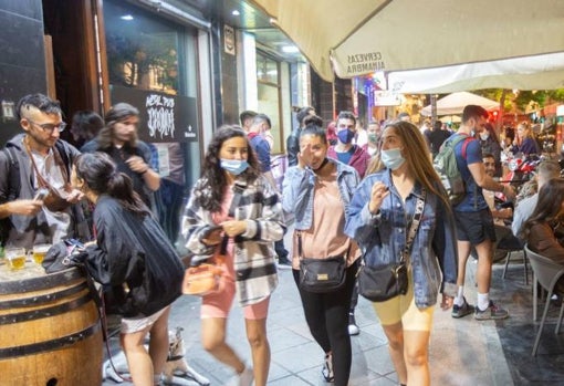 Gente paseando por las calles llenas bares abiertos aunque con mascarilla