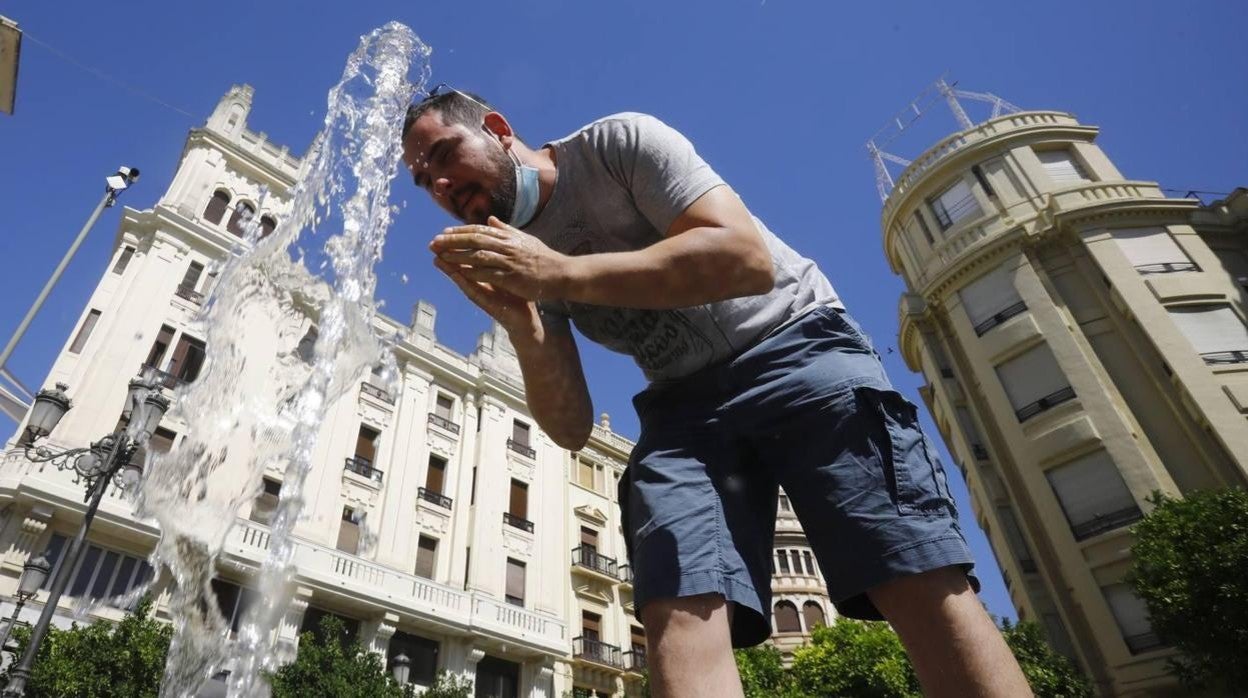 Un hombre se refresca en los chorros de Las Tendillas