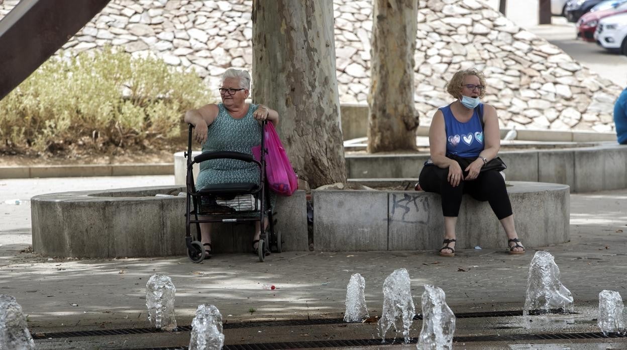 Dos mujeres toman el aire en una plaza del Sector Sur en Córdoba