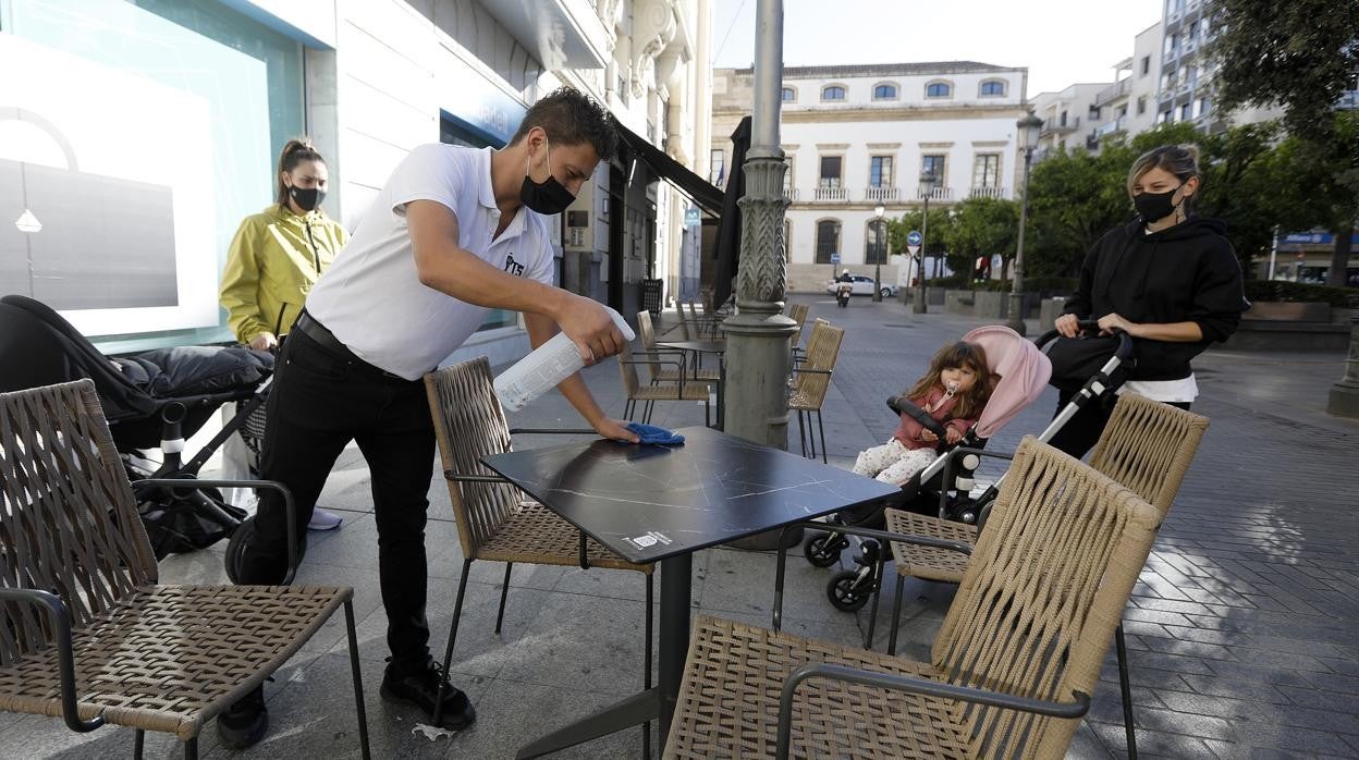 Un camarero limpia una mesa en Las Tendillas