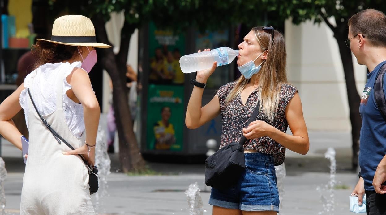 Dos mujeres se refrescan en la plaza de Las Tendillas de Córdoba