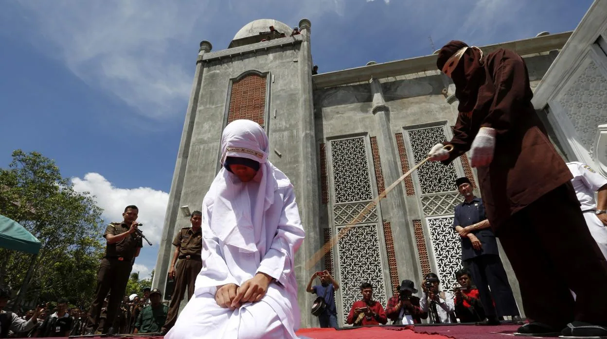 Una mujer es azotada en público en un castigo de la sharía en Indonesia