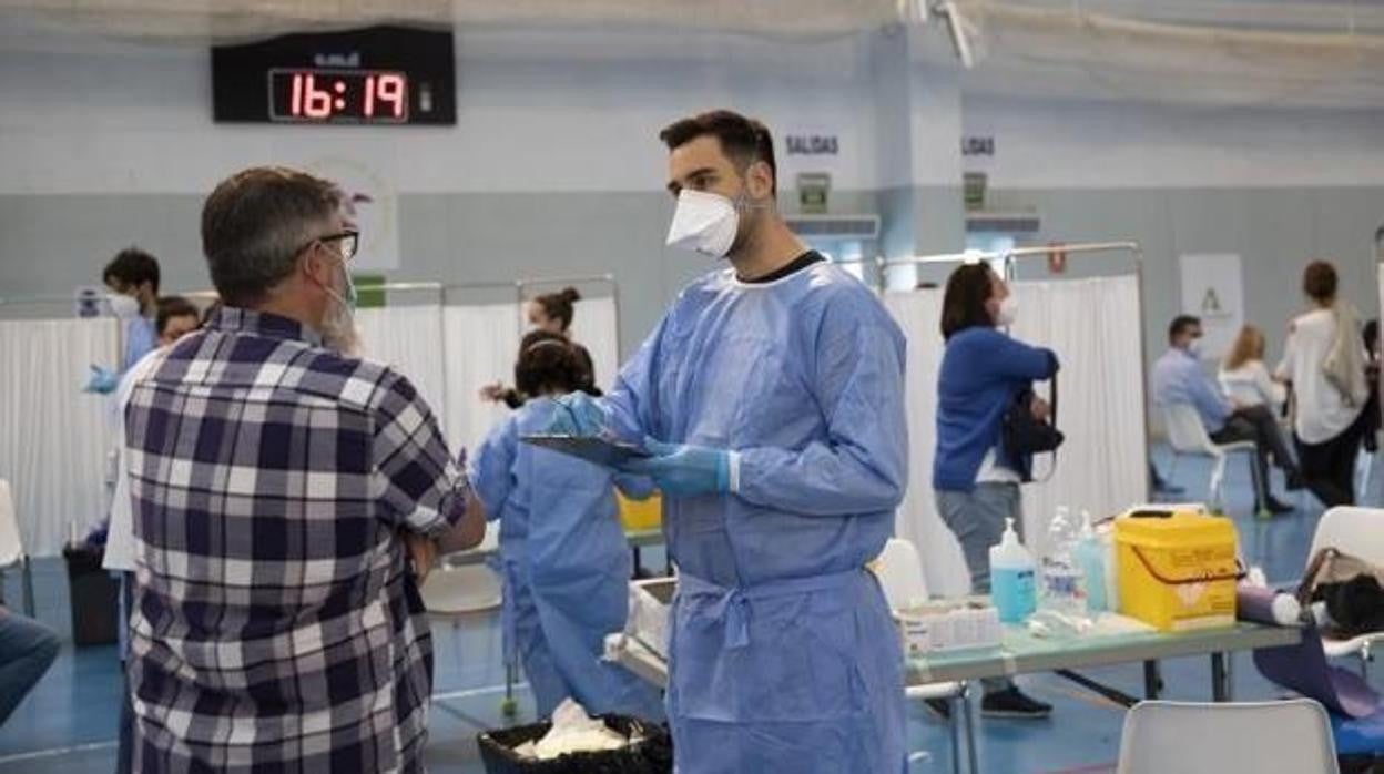 Un sanitario atiende a ciudadanos en un centro de vacunación contra el Covid