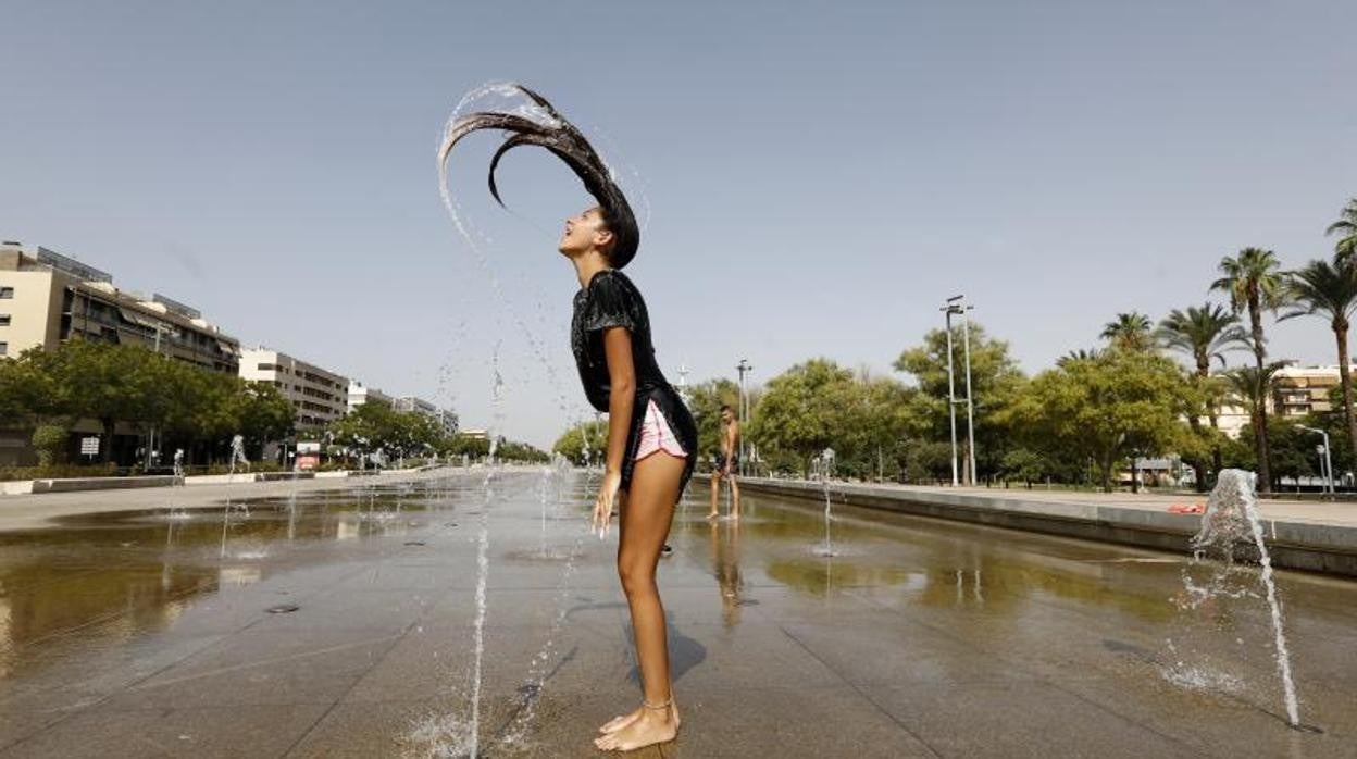 Una mujer se refresca en el Vial Norte el 14 de agosto, durante la ola de calor