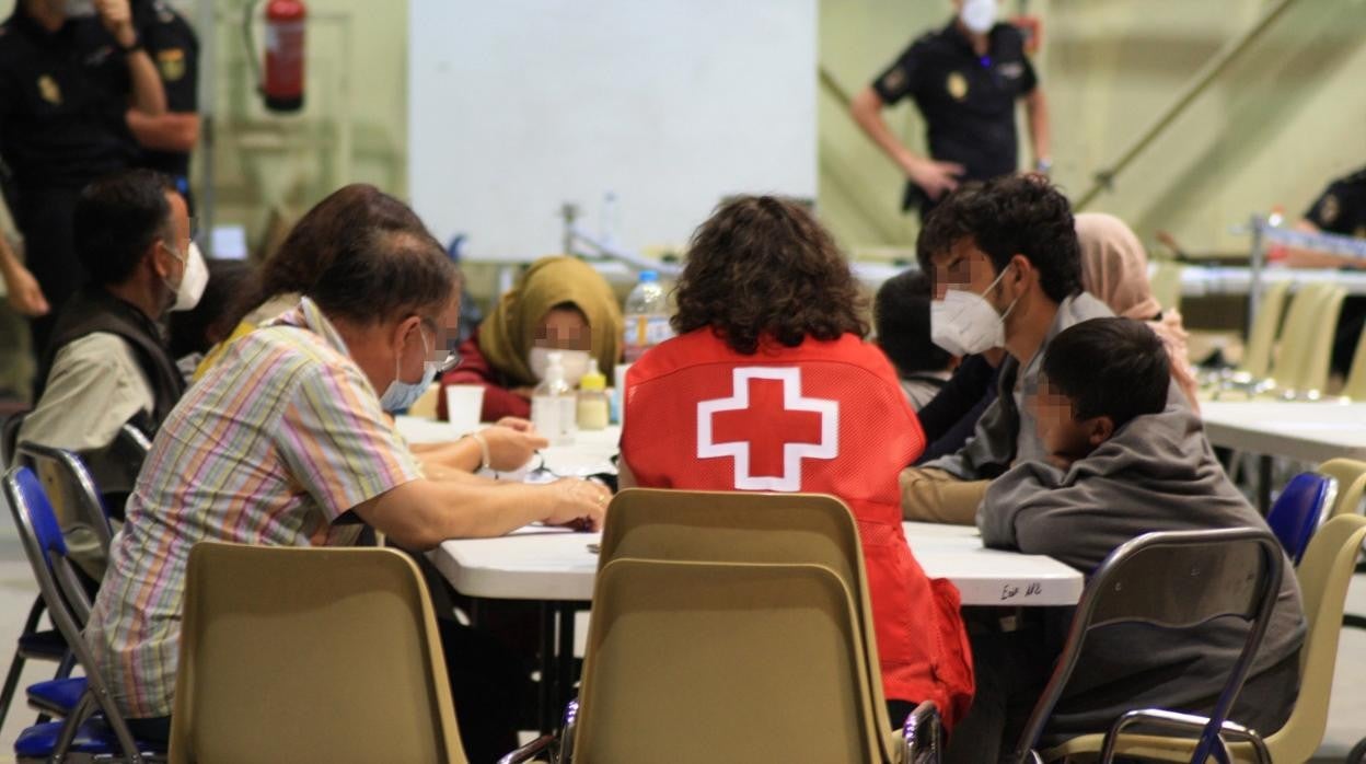 Voluntarios de Cruz Roja con refugiados afganos