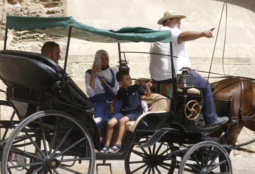 Una familia pasea en coche de caballos por Córdoba