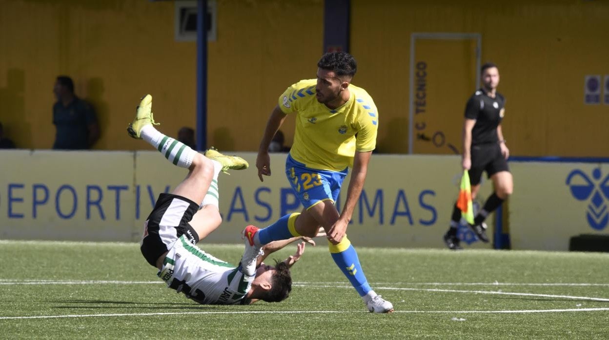 Javi Flores por el suelo ante Cristian Abreu en el Las Palmas Atlético - Córdoba CF