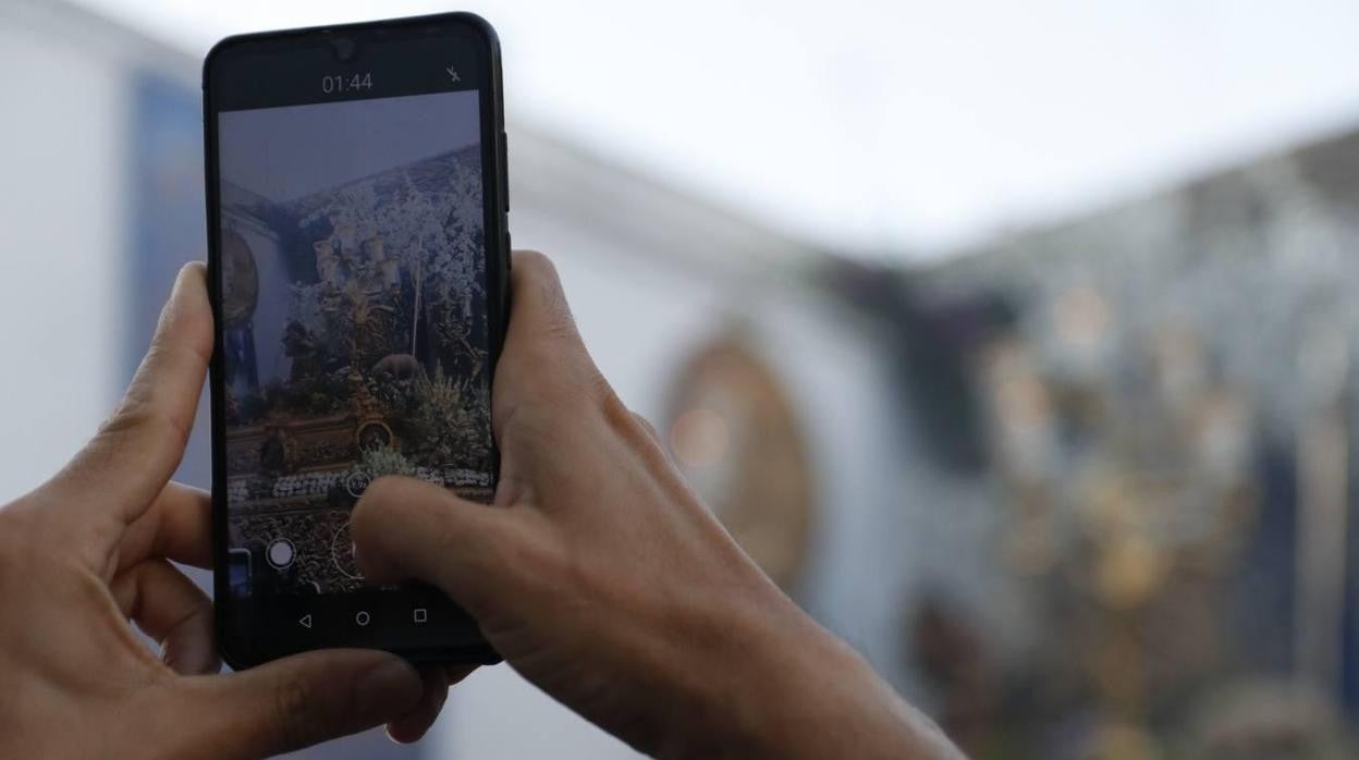 Un hombre fotogafría la salida de la Divina Pastora, primera procesión en Córdoba tras el Covid