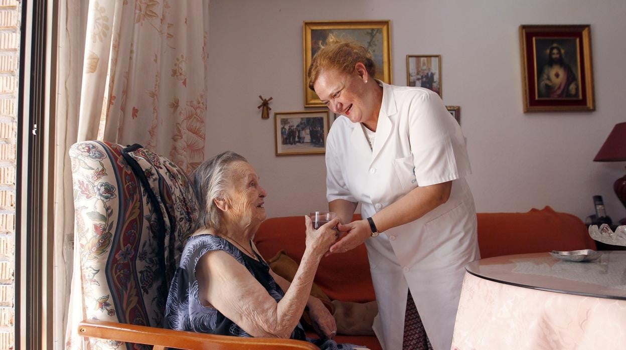 Una anciana recibe la atención de una trabajadora social