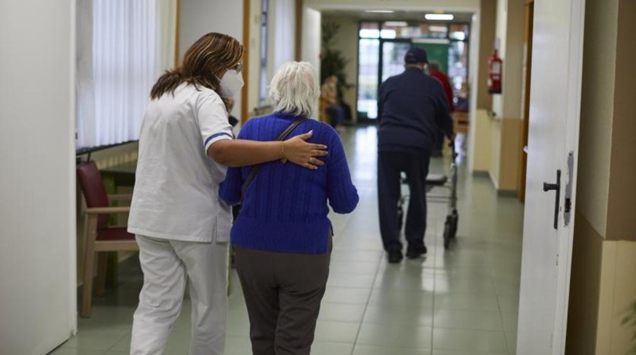 Una trabajadora acompaña a una mujer en una residencia de mayores