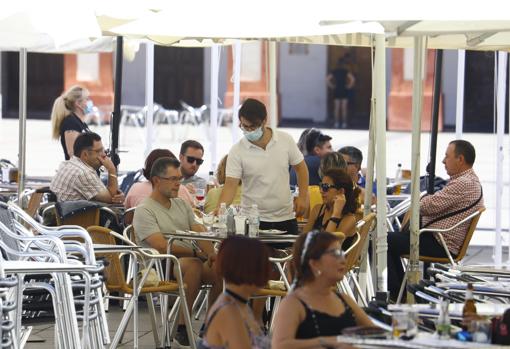 Un camarero atiende una mesa en la plaza de La Corredera