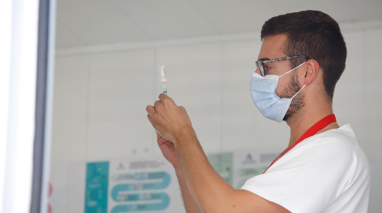 Un sanitario con una vacuna en el autobús de la Consejería de Salud instalado en Córdoba