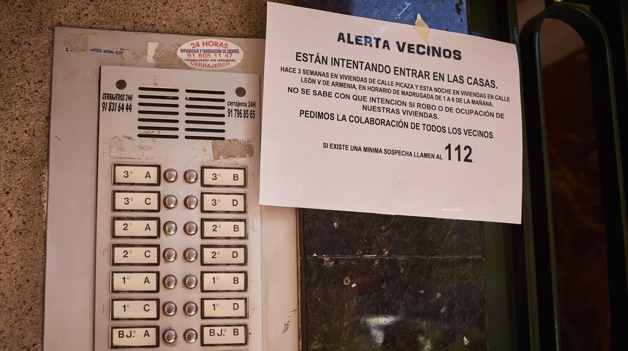 Cartel en la puerta de un bloque de viviendas alertando a los vecinos de robos en las casas