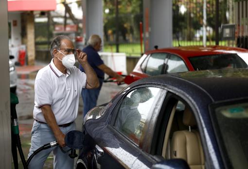 Un hombre reposta en la gasolinera del parque de Colón