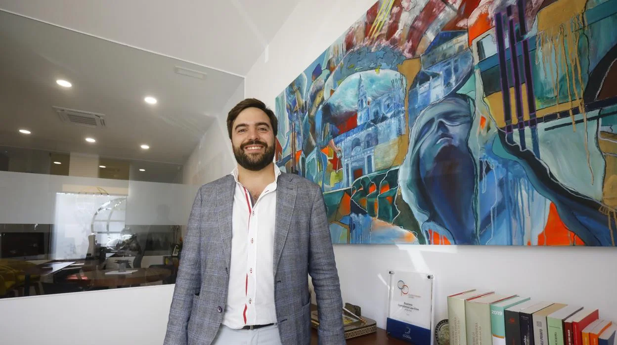 Rafael Aguirre posa en su despacho junto a un cuadro con una alegoría de la justicia