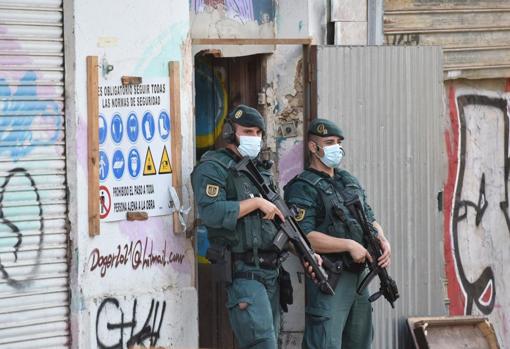 Dos agentes custodian un acceso a un edificio