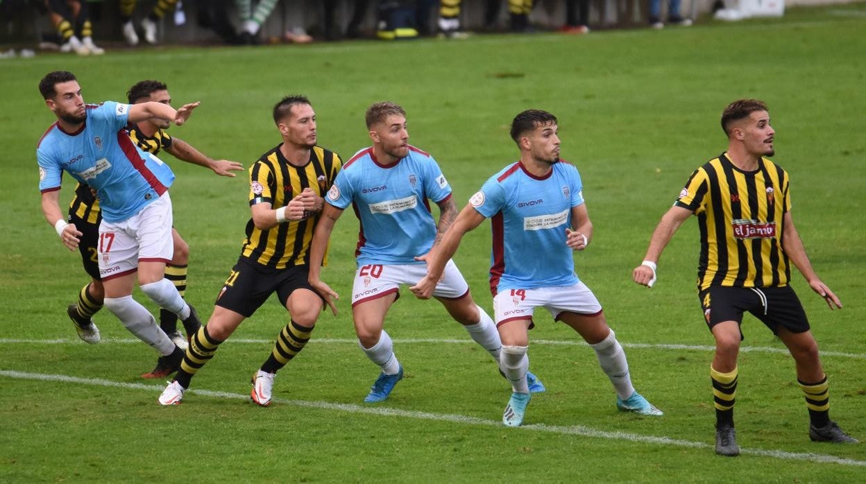 Cruz y Alonso, pareja de centrales de Córdoba CF, con Casas en el centro, durante el choque en Lepe // LOF