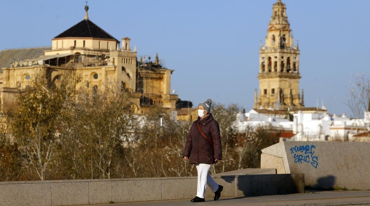 Una mujer pasea por el puente de Miraflores, con la Mezquita-Catedral de fondo