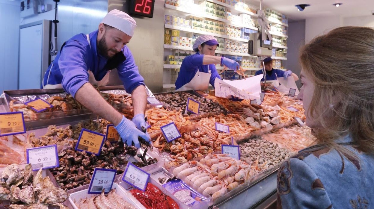 Una mujer compra pescado en Navidad