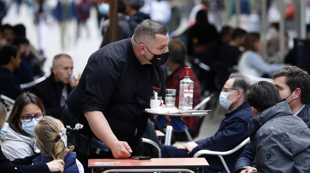 Un camarero atiende una mesa en una terraza del Centro