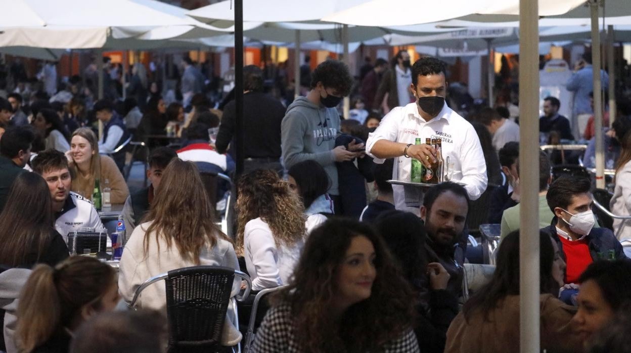 Un camarero atiende una mesa en una de las terrazas de la plaza de la Corredera